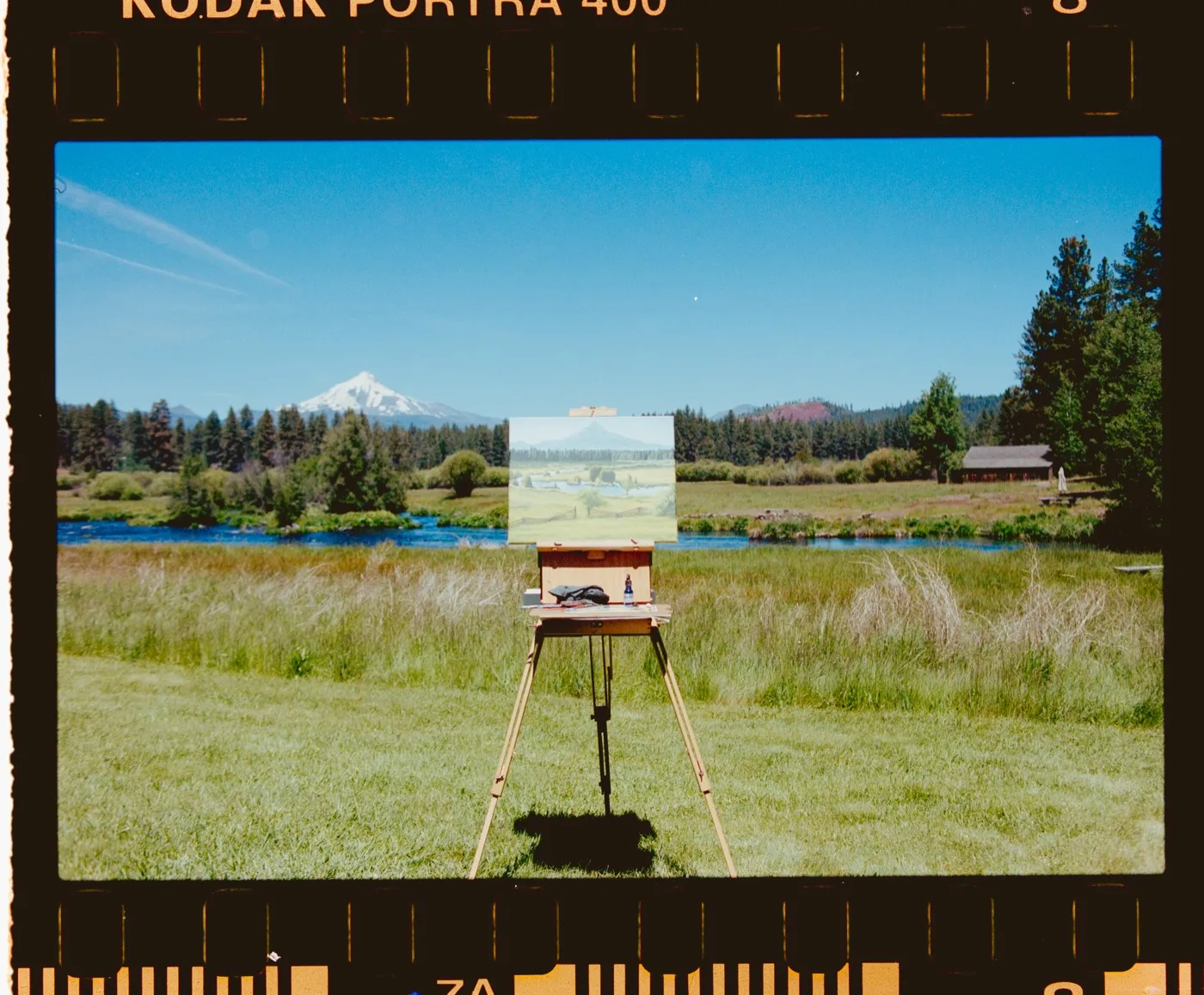 Film scan of Holly's easel and painting setup by the river, Mt. Hood in the distance