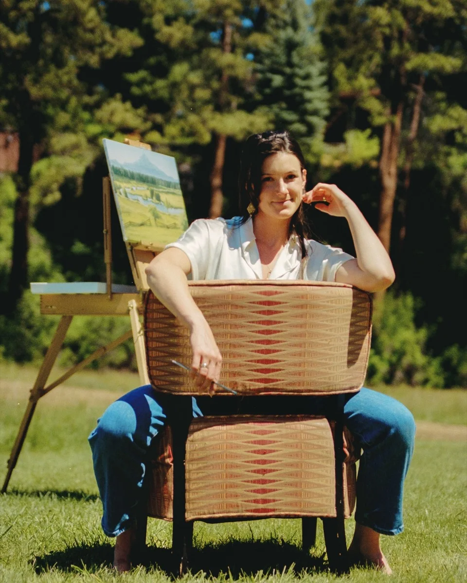 Holly Di Cecco with her easel and painting, outdoors
